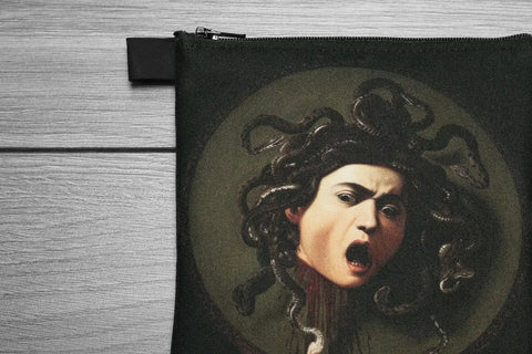 Black pouch with Medusa design on a wooden surface