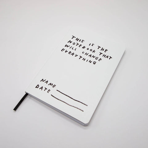 White notebook with text and a pen on a light gray background